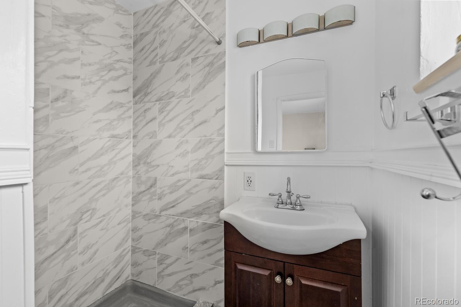 3106 South Wolff Street Denver, CO 80236 - Photo 19 of 48 a sink sitting in a bathroom and mirror