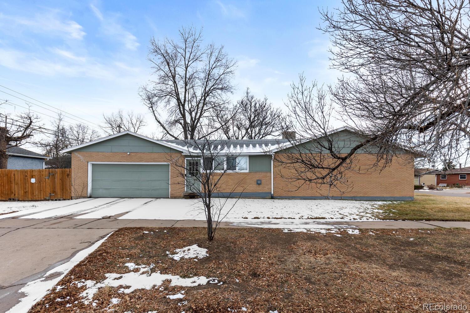 3106 South Wolff Street Denver, CO 80236 - Photo 2 of 48 a front view of a house with a yard and garage