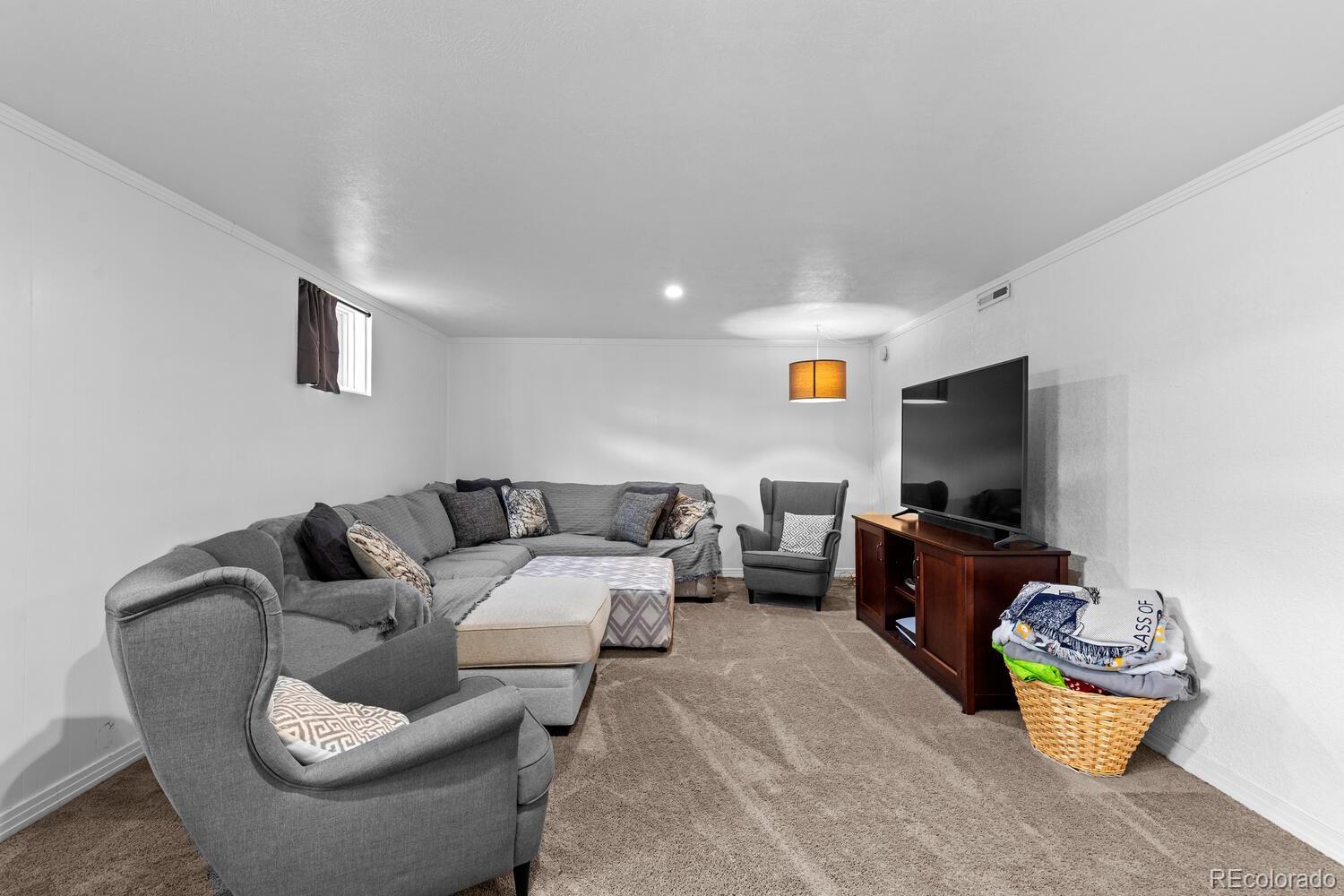 3106 South Wolff Street Denver, CO 80236 - Photo 23 of 48 a living room with furniture and a flat screen tv