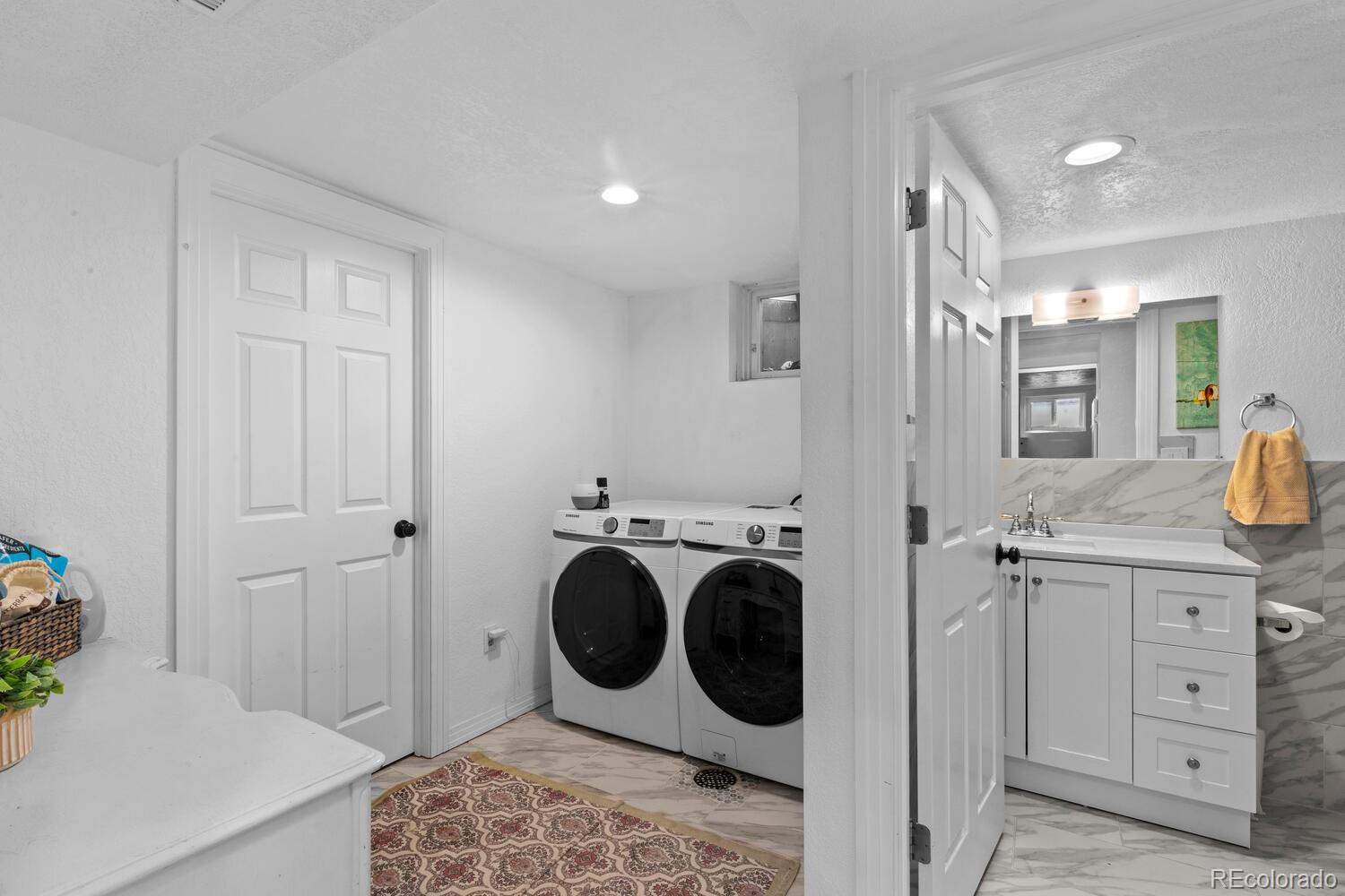 3106 South Wolff Street Denver, CO 80236 - Photo 26 of 48 a spacious bathroom with a sink and a mirror