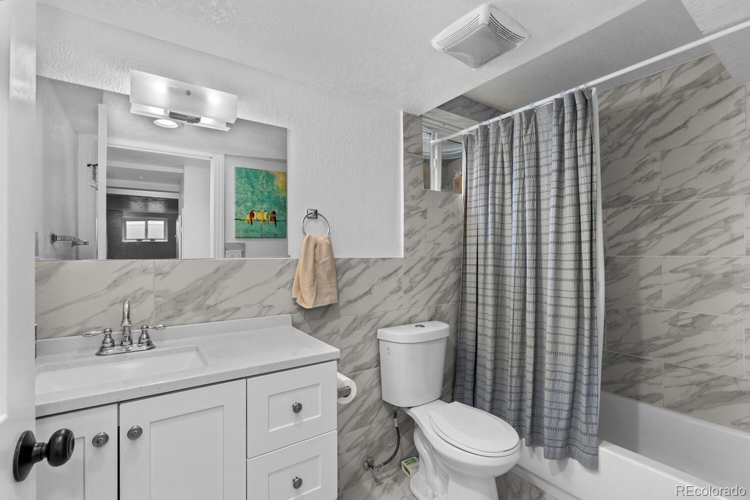 3106 South Wolff Street Denver, CO 80236 - Photo 27 of 48 a bathroom with a granite countertop sink toilet and shower