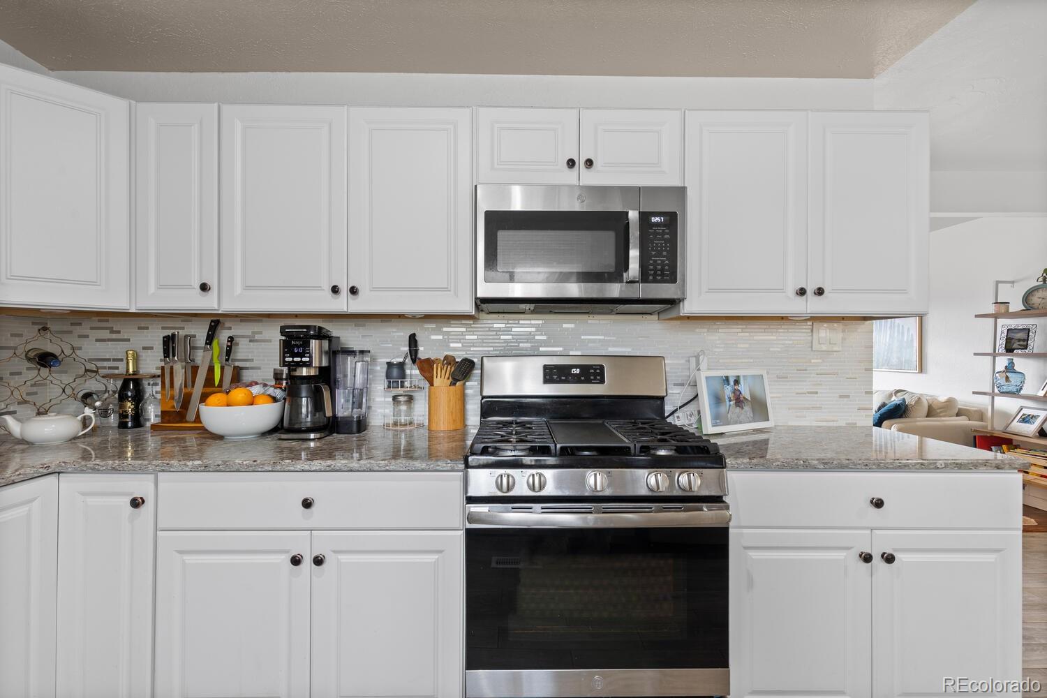 3106 South Wolff Street Denver, CO 80236 - Photo 38 of 48 a kitchen with cabinets appliances a sink and a counter top