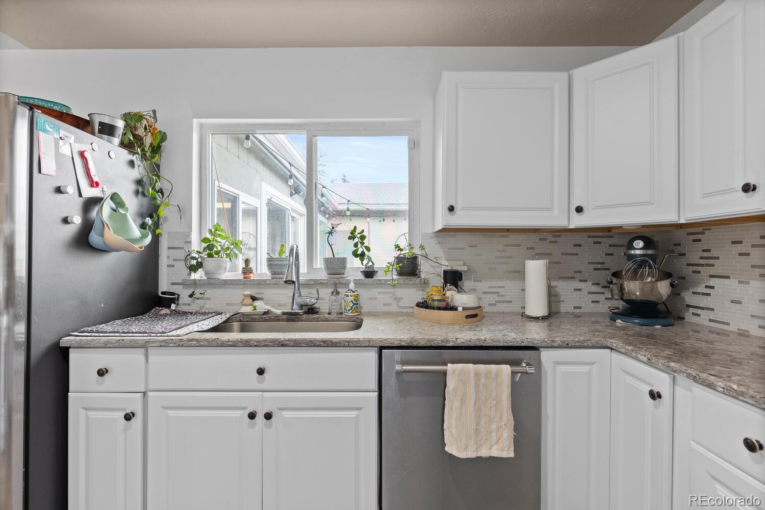 3106 South Wolff Street Denver, CO 80236 - Photo 8 of 48 a kitchen with stainless steel appliances granite countertop a sink stove and cabinets