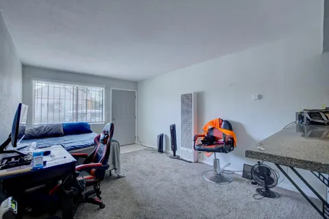 a view of a workspace with furniture and gym cycle