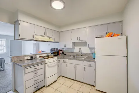 a kitchen with appliances a sink and cabinets