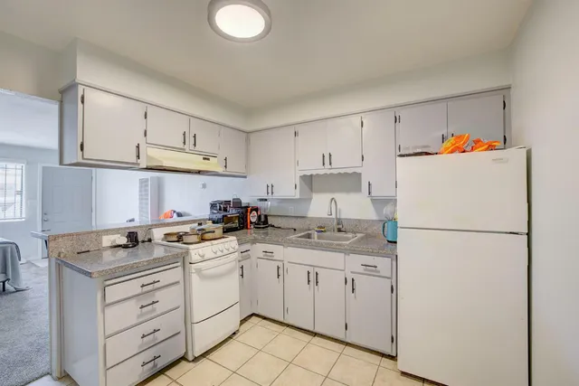 a kitchen with appliances a sink and cabinets