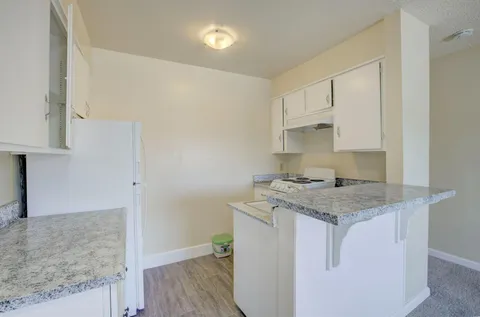 a utility room with granite countertop a sink and a stove