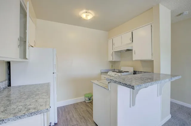 a utility room with granite countertop a sink and a stove