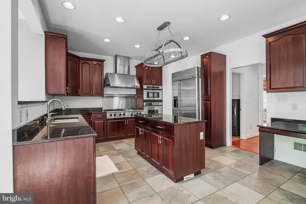 a kitchen with stainless steel appliances granite countertop a stove a sink and a refrigerator