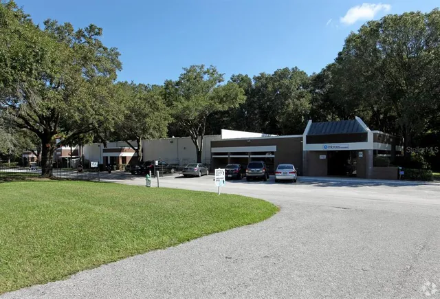 a front view of a house with a garden and trees