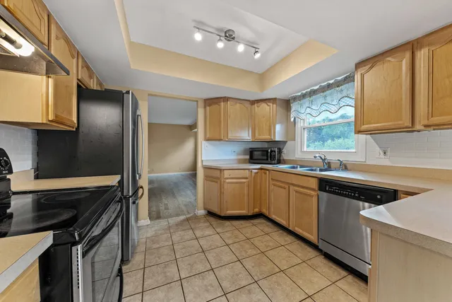 a kitchen with a sink cabinets stainless steel appliances and a window