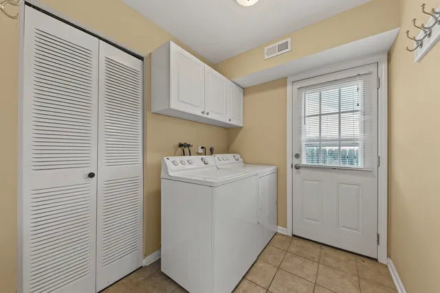 a utility room with cabinets washer and dryer