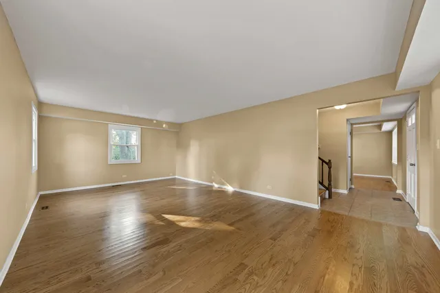 an empty room with wooden floor and mirror