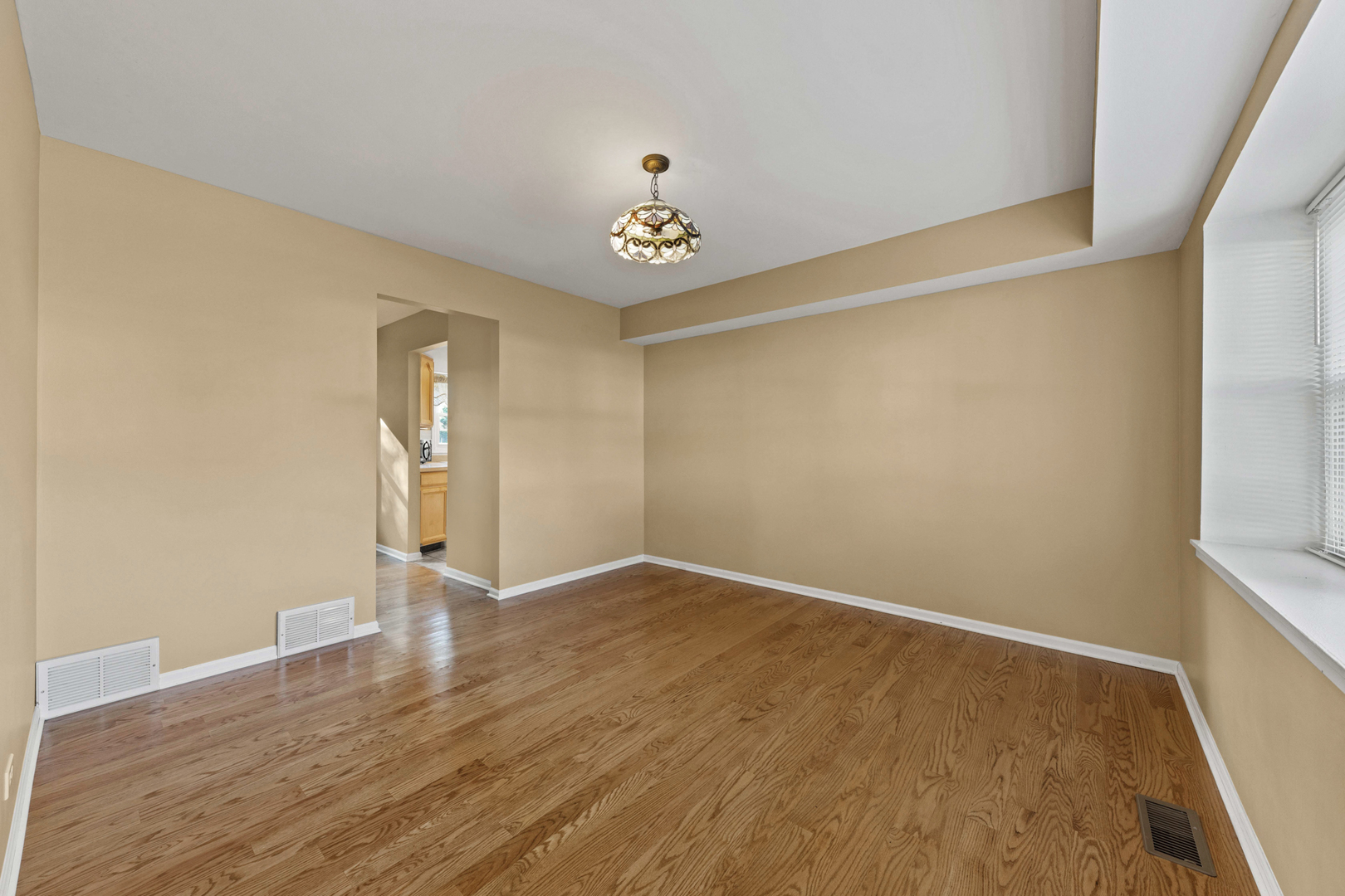 1121 Belmar Lane Buffalo Grove, IL 60089 - Photo 7 of 22 an empty room with wooden floor and windows
