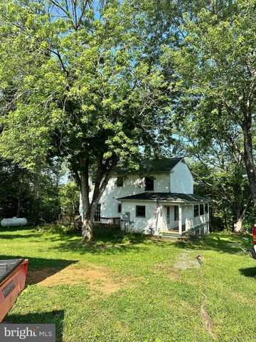 a front view of a house with yard and green space