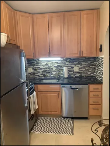 a kitchen with stainless steel appliances granite countertop a refrigerator sink and cabinets