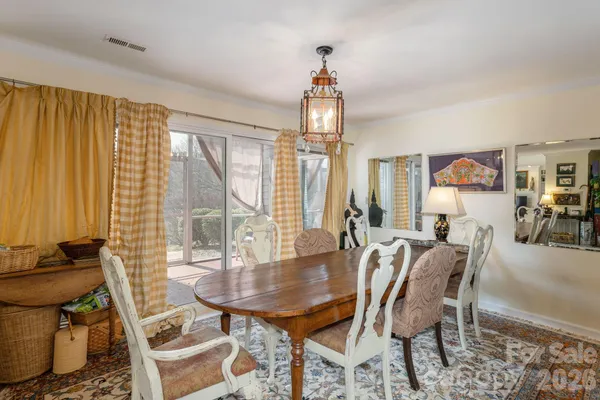 a dining room with furniture a chandelier and wooden floor