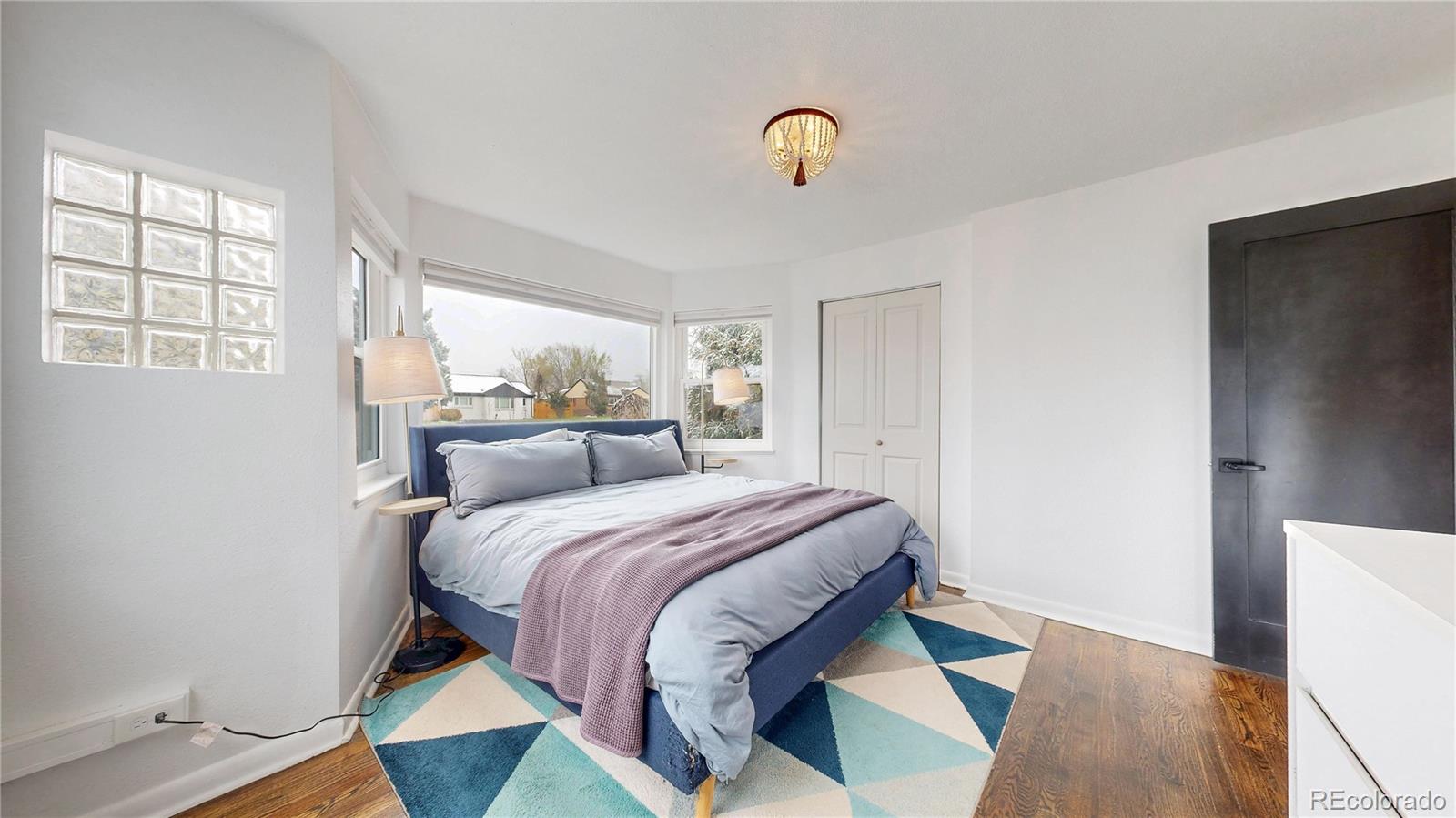 3155 Steele Street Denver, CO 80205 - Photo 11 of 37 a bedroom with a bed and wooden floor