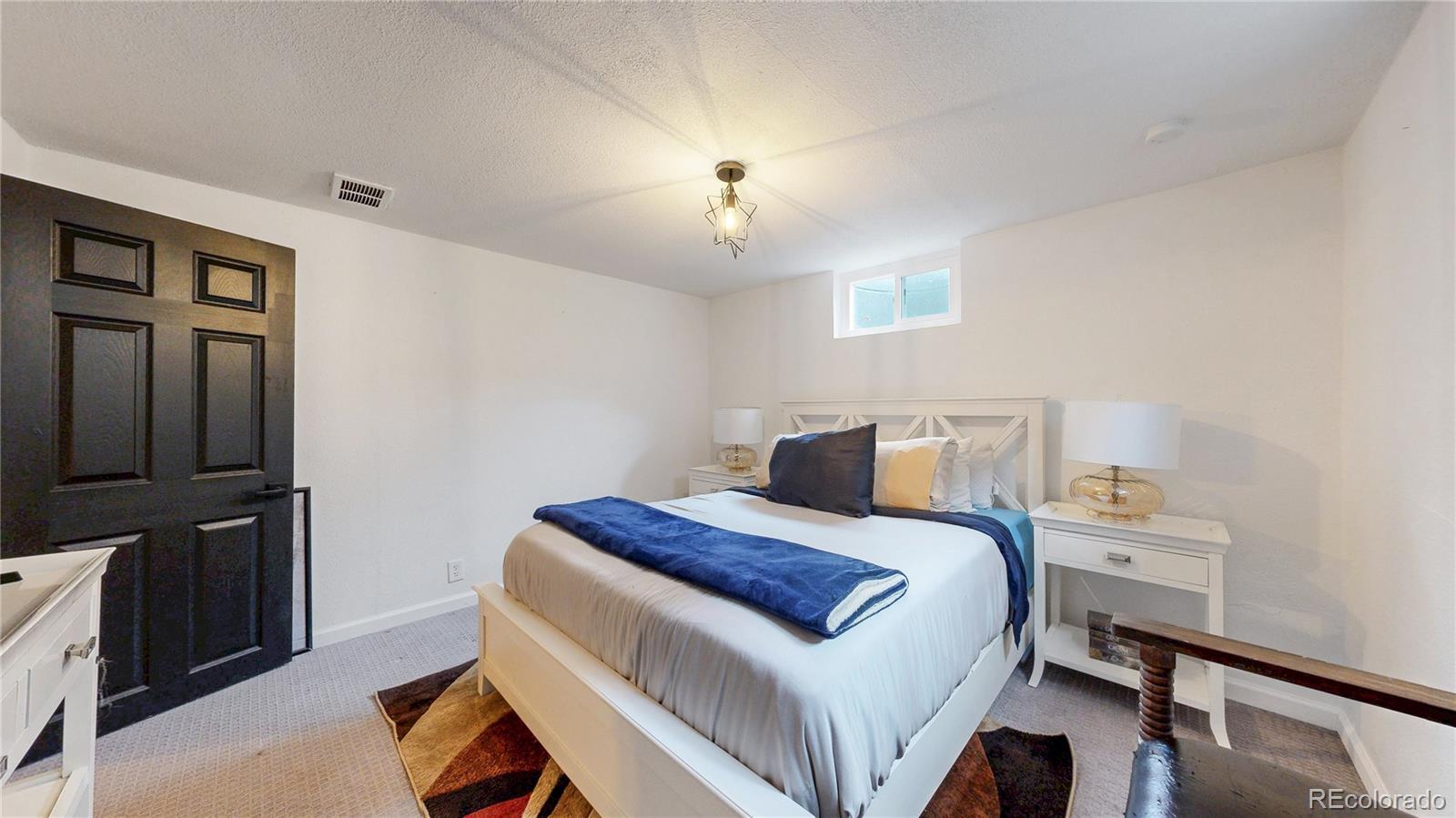 3155 Steele Street Denver, CO 80205 - Photo 20 of 37 a bedroom with a bed and a chandelier