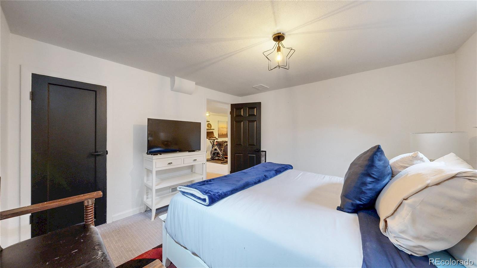 3155 Steele Street Denver, CO 80205 - Photo 21 of 37 a bedroom with a bed and a flat screen tv