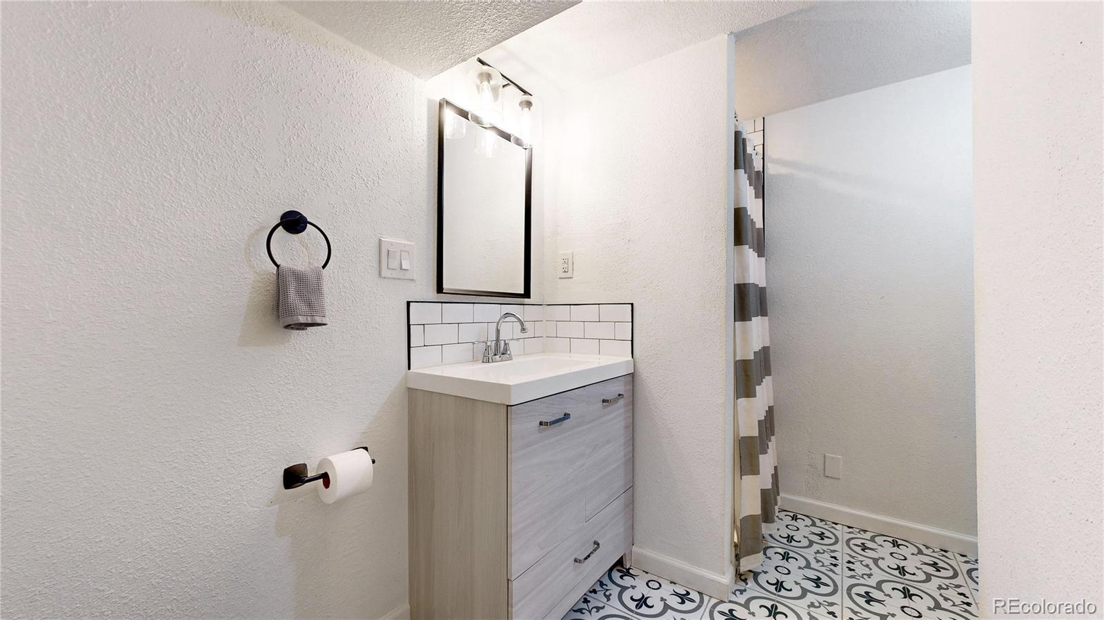 3155 Steele Street Denver, CO 80205 - Photo 25 of 37 a bathroom with a sink and a mirror