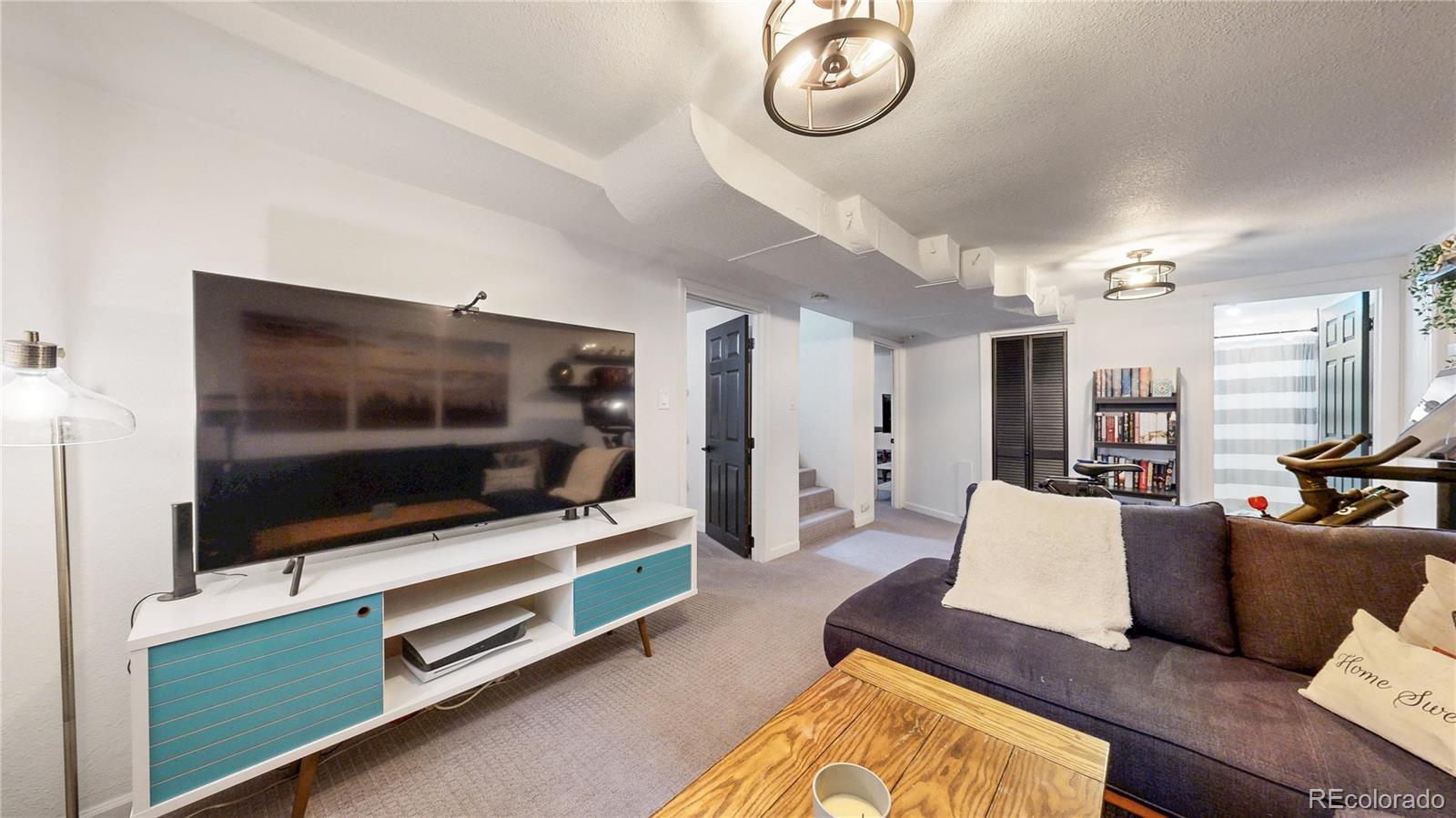3155 Steele Street Denver, CO 80205 - Photo 26 of 37 a living room with furniture and a flat screen tv