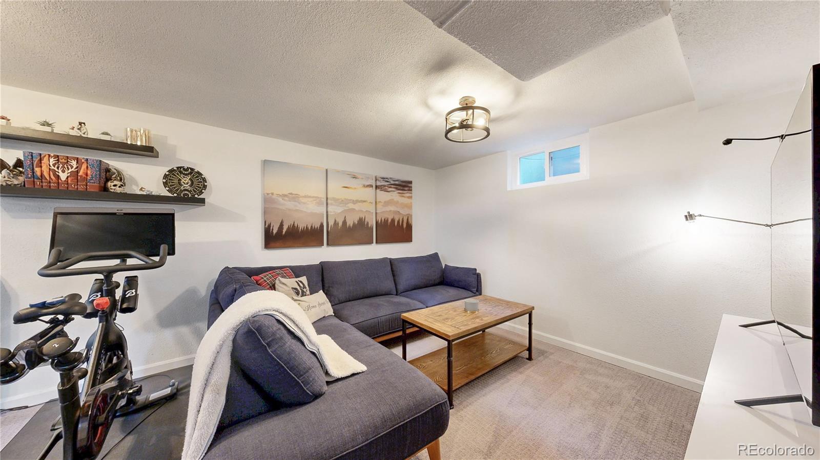 3155 Steele Street Denver, CO 80205 - Photo 28 of 37 a living room with furniture and a flat screen tv
