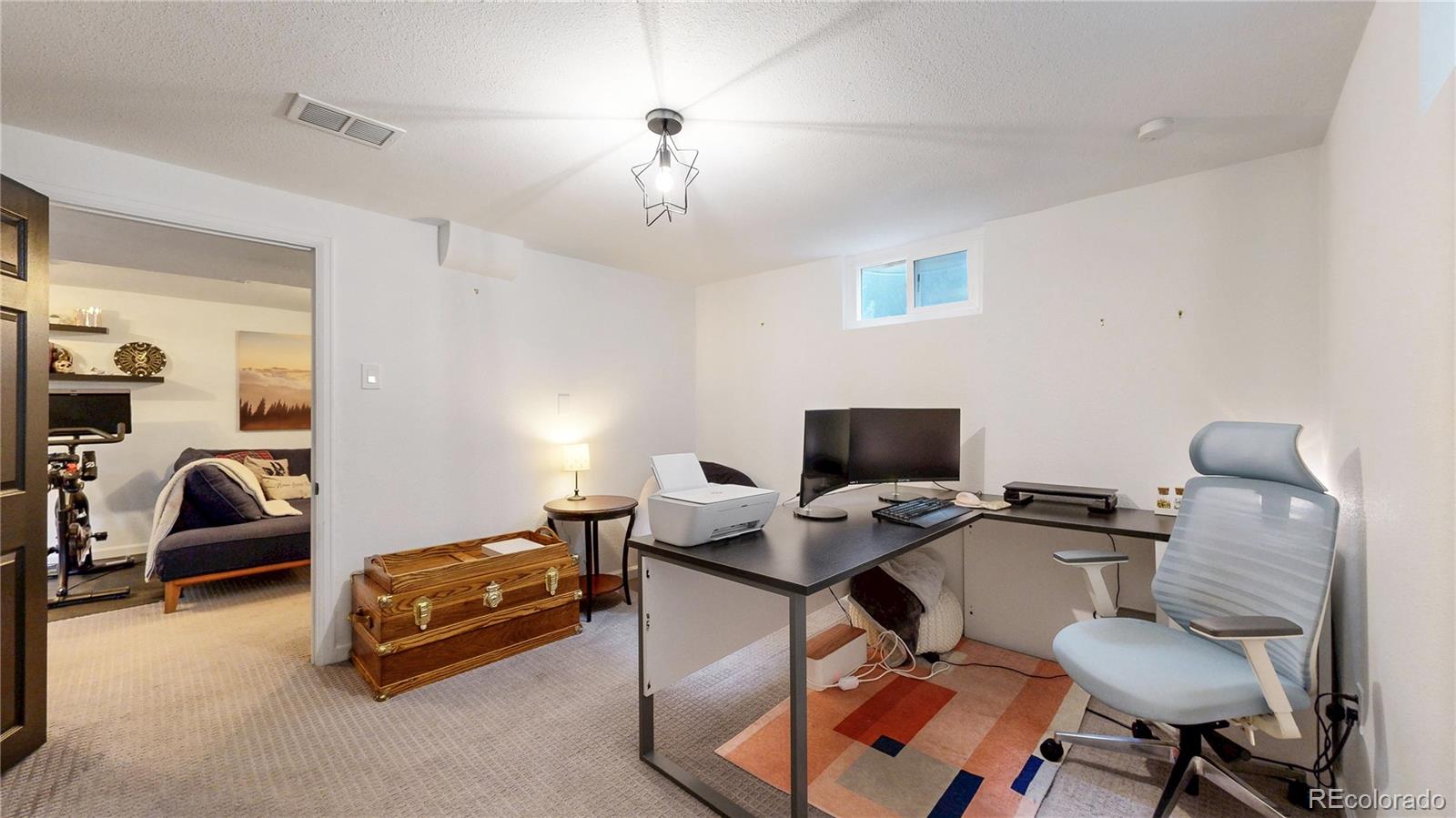 3155 Steele Street Denver, CO 80205 - Photo 30 of 37 a livingroom with workspace and a couch