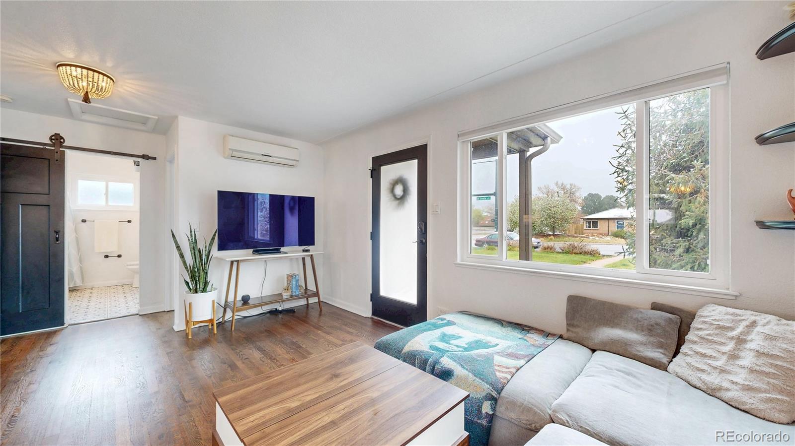 3155 Steele Street Denver, CO 80205 - Photo 4 of 37 a living room with furniture a flat screen tv and a large window