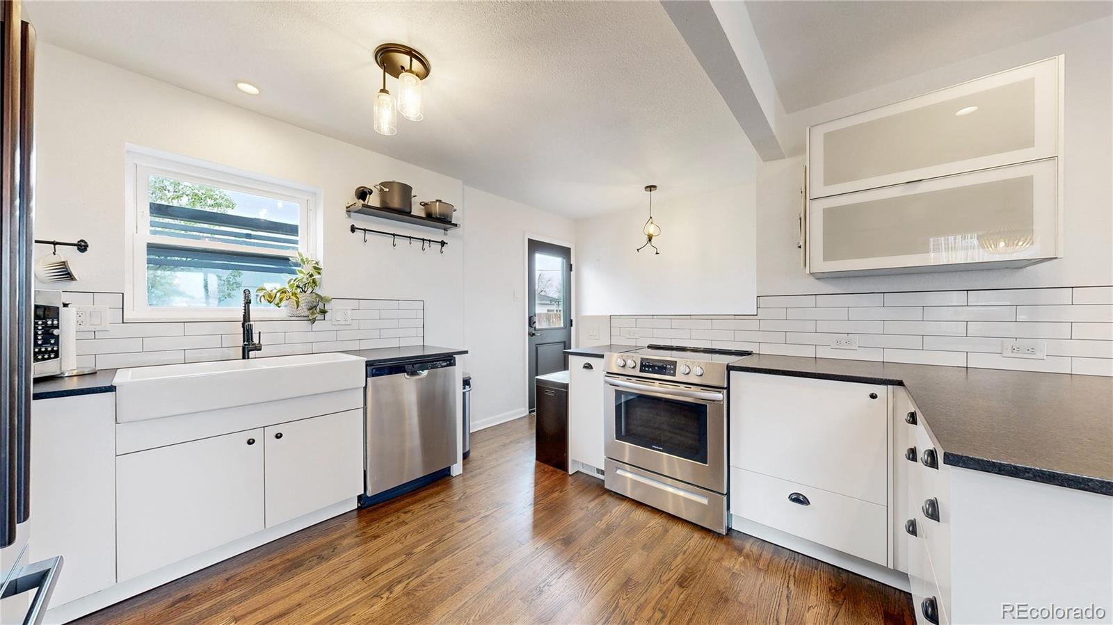 3155 Steele Street Denver, CO 80205 - Photo 7 of 37 a kitchen with a stove a sink and a microwave