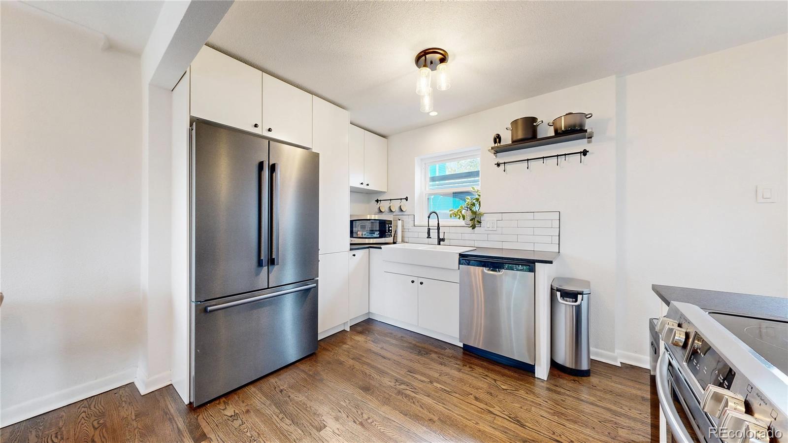 3155 Steele Street Denver, CO 80205 - Photo 9 of 37 a kitchen with stainless steel appliances a refrigerator sink and microwave
