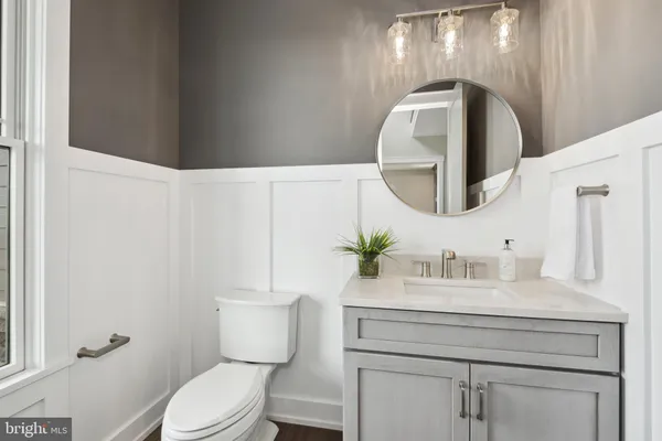 a bathroom with a toilet sink vanity and mirror