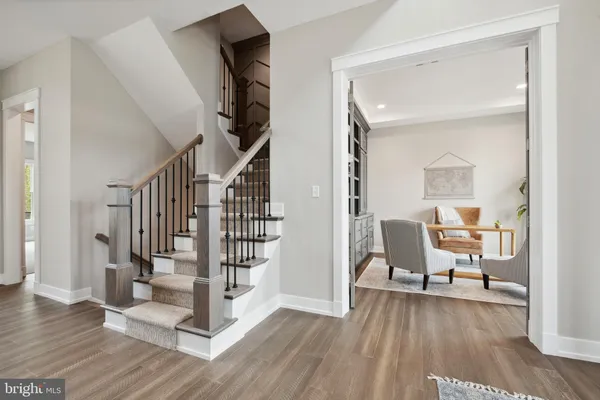 a view of a hallway with wooden floor and furniture