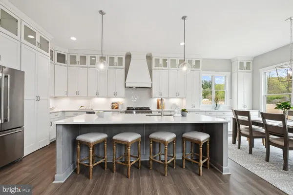a kitchen with stainless steel appliances granite countertop a dining table chairs sink and cabinets