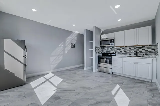 a kitchen with stainless steel appliances granite countertop a refrigerator and a stove top oven