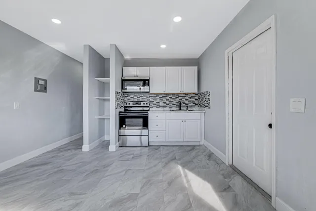 a view of kitchen with sink and refrigerator