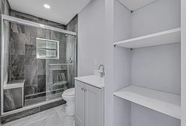 a bathroom with a sink a toilet and shower