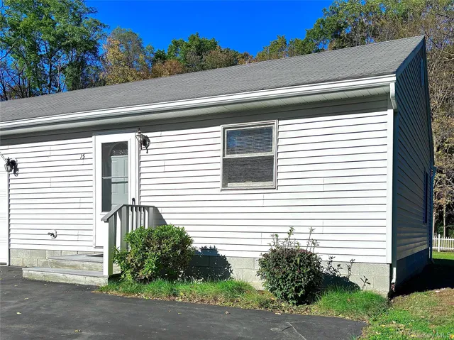 a view of a house with a yard and potted plants