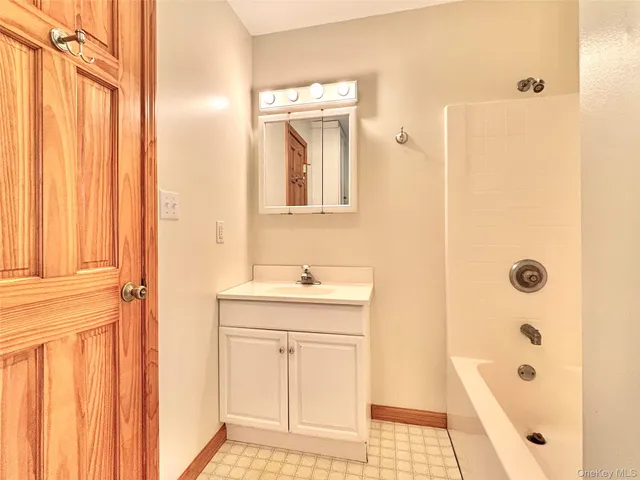 a bathroom with a bathtub a sink a vanity and a mirror