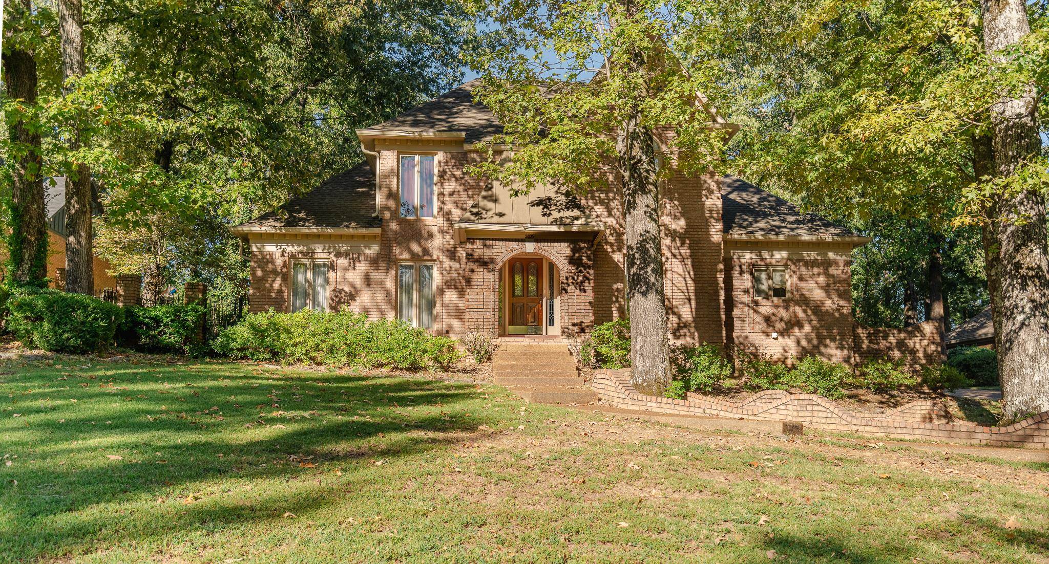 View of front of property featuring a front yard, brick siding, and a shingled roof
