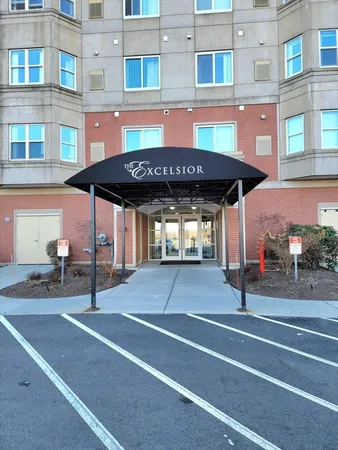 a view of a building with a table and chairs under an umbrella