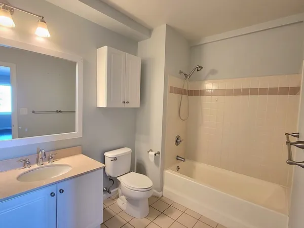 a bathroom with a granite countertop sink a toilet and shower