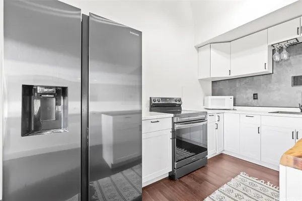 a kitchen with white cabinets and white appliances