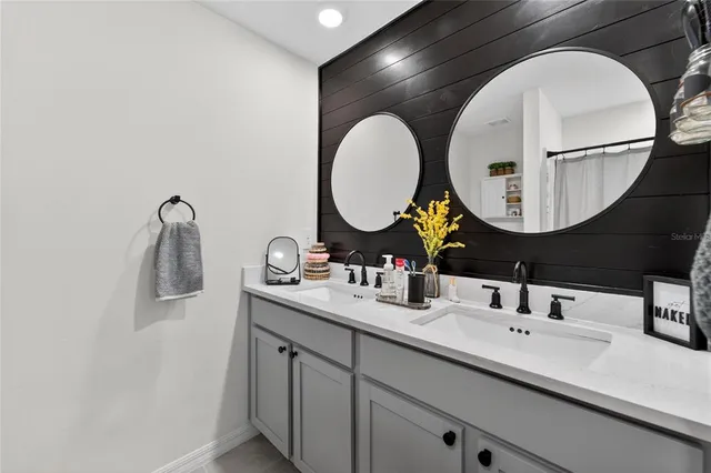 a bathroom with a double vanity sink and a mirror