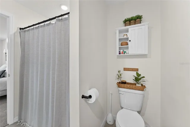a white toilet sitting next to a shower curtain