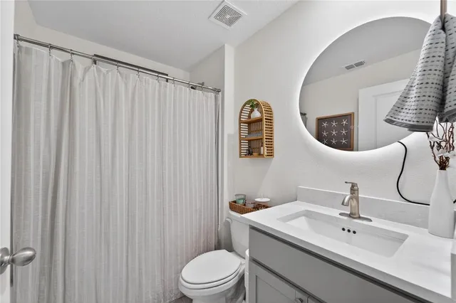 a bathroom with a sink vanity mirror and toilet