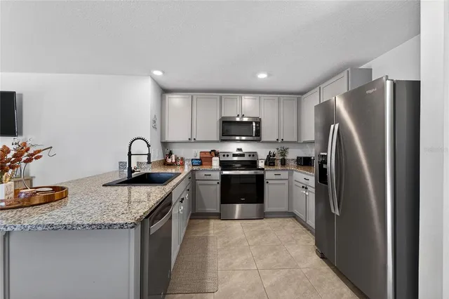 a kitchen with a refrigerator a sink a stove a microwave and cabinets