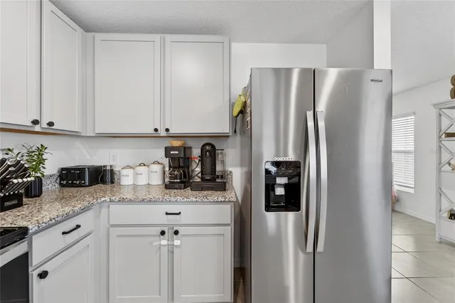 a kitchen with stainless steel appliances white cabinets and a refrigerator