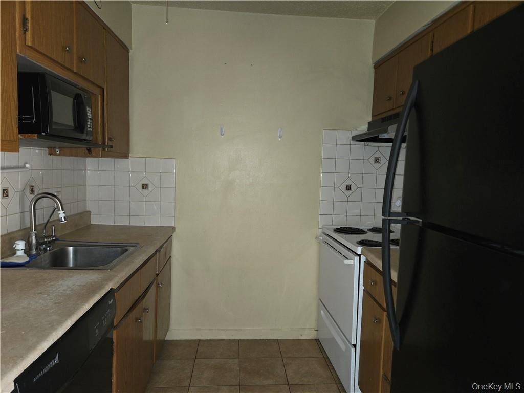 44 Inwood Road Middletown, NY 10941 - Photo 6 of 15 Kitchen with dark tile patterned floors, black appliances, range hood, sink, and decorative backsplash