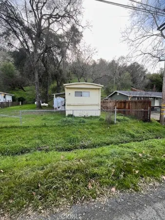 a view of a house with a big yard and large trees